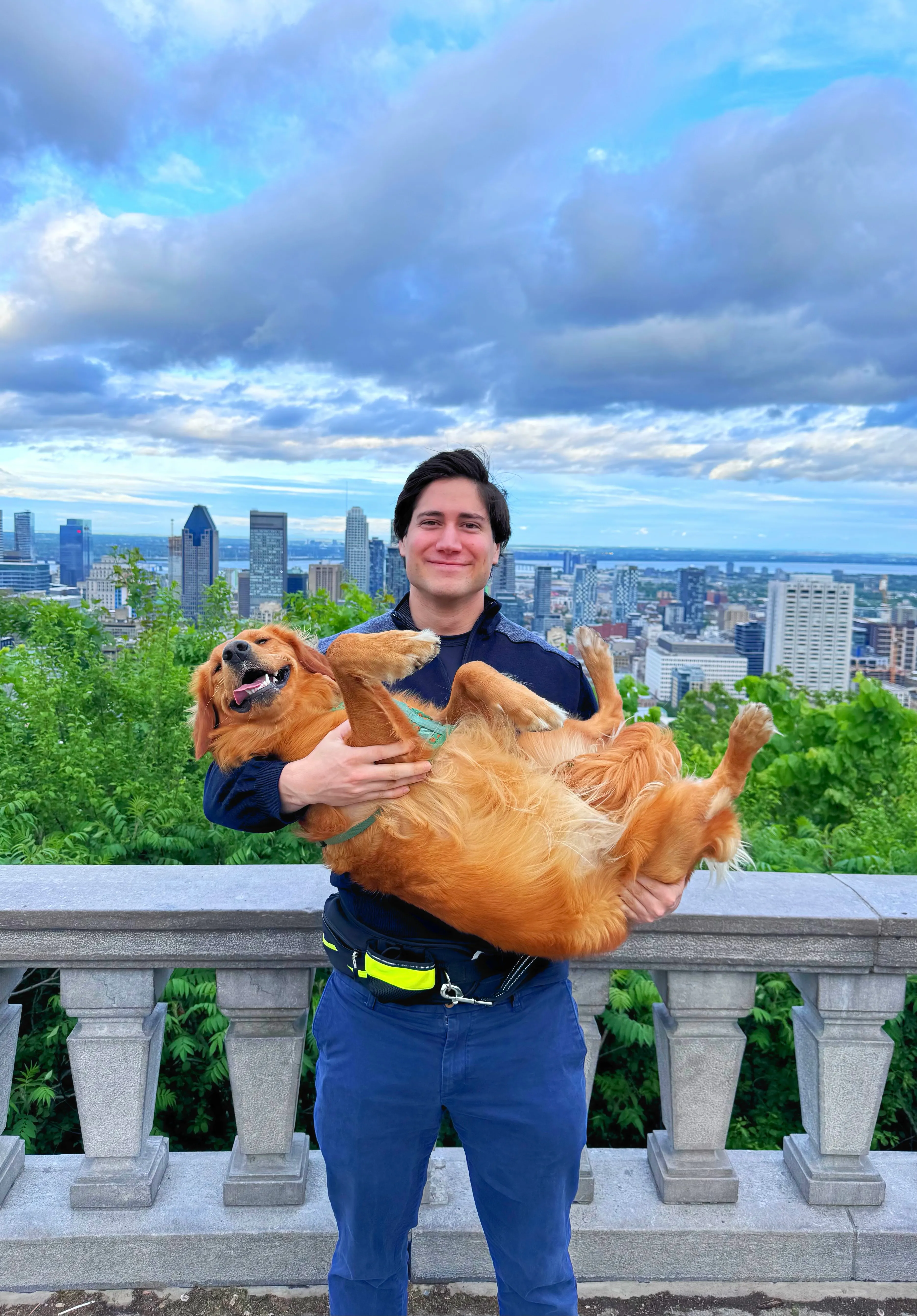 Laurent Lefebvre overlooking Montréal, holding his golden retriever